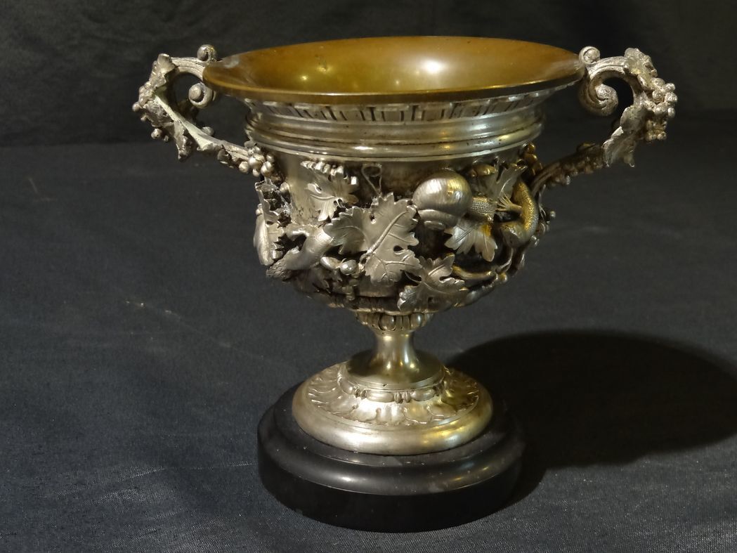 Carved silver bronze vase mounted on marble pedestal