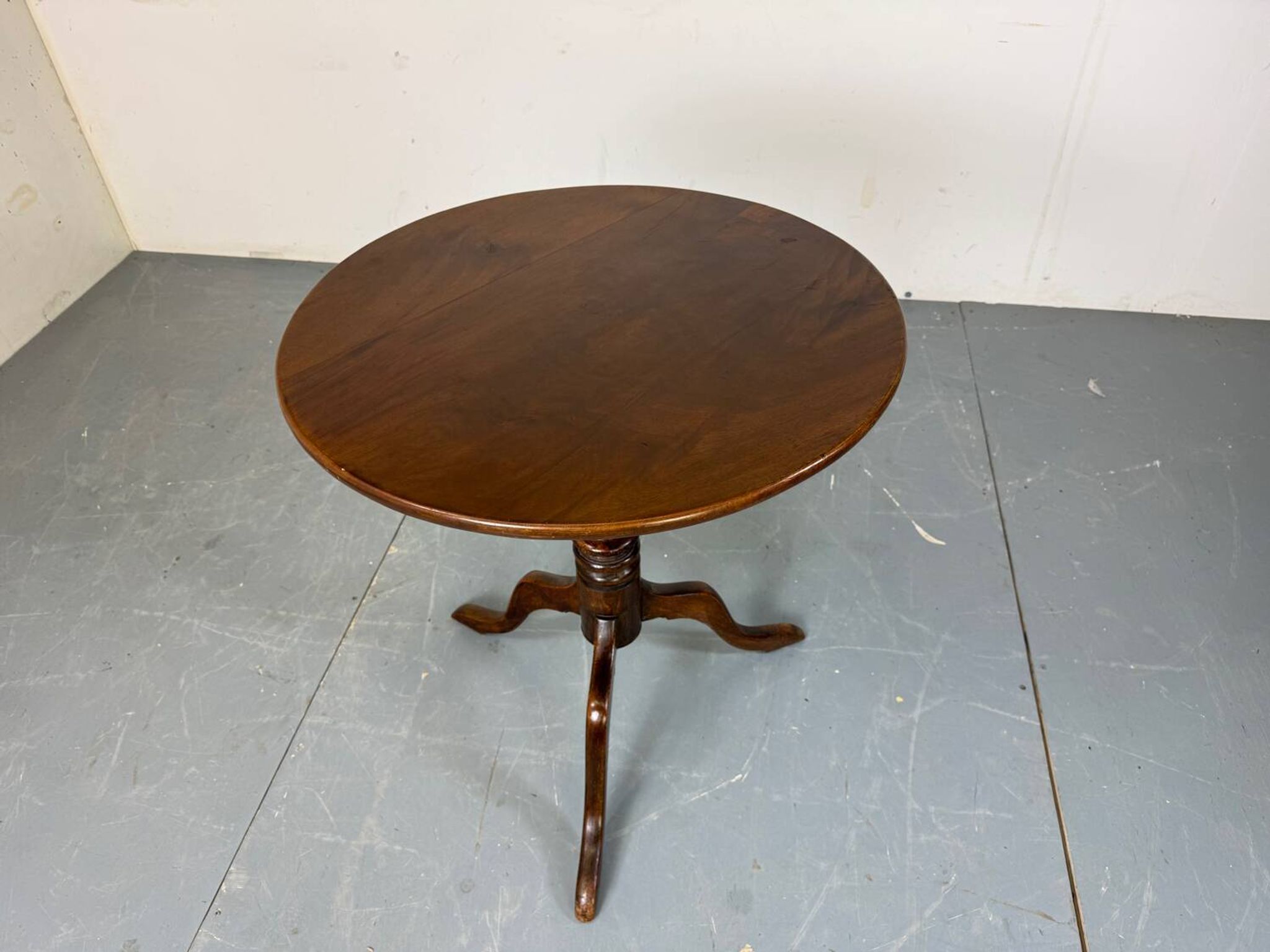 Round coffee table with an adjustable top in antique mahogany.