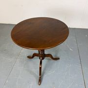 Round coffee table with an adjustable top in antique mahogany.
