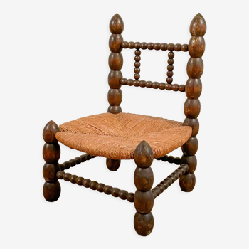 Low chair in beaded wood and straw