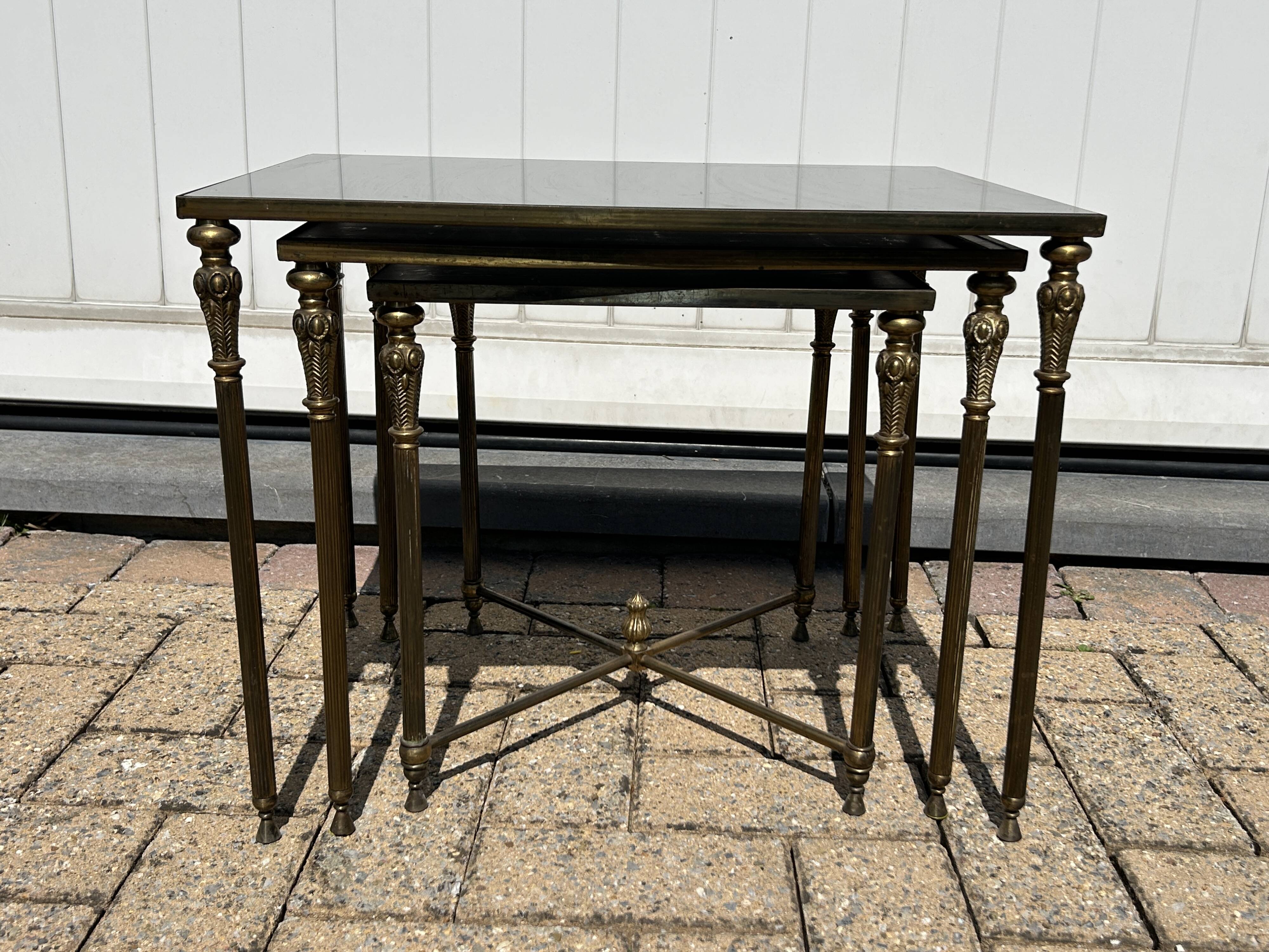 Nested tables in gilded brass in the style of Maison Charles.