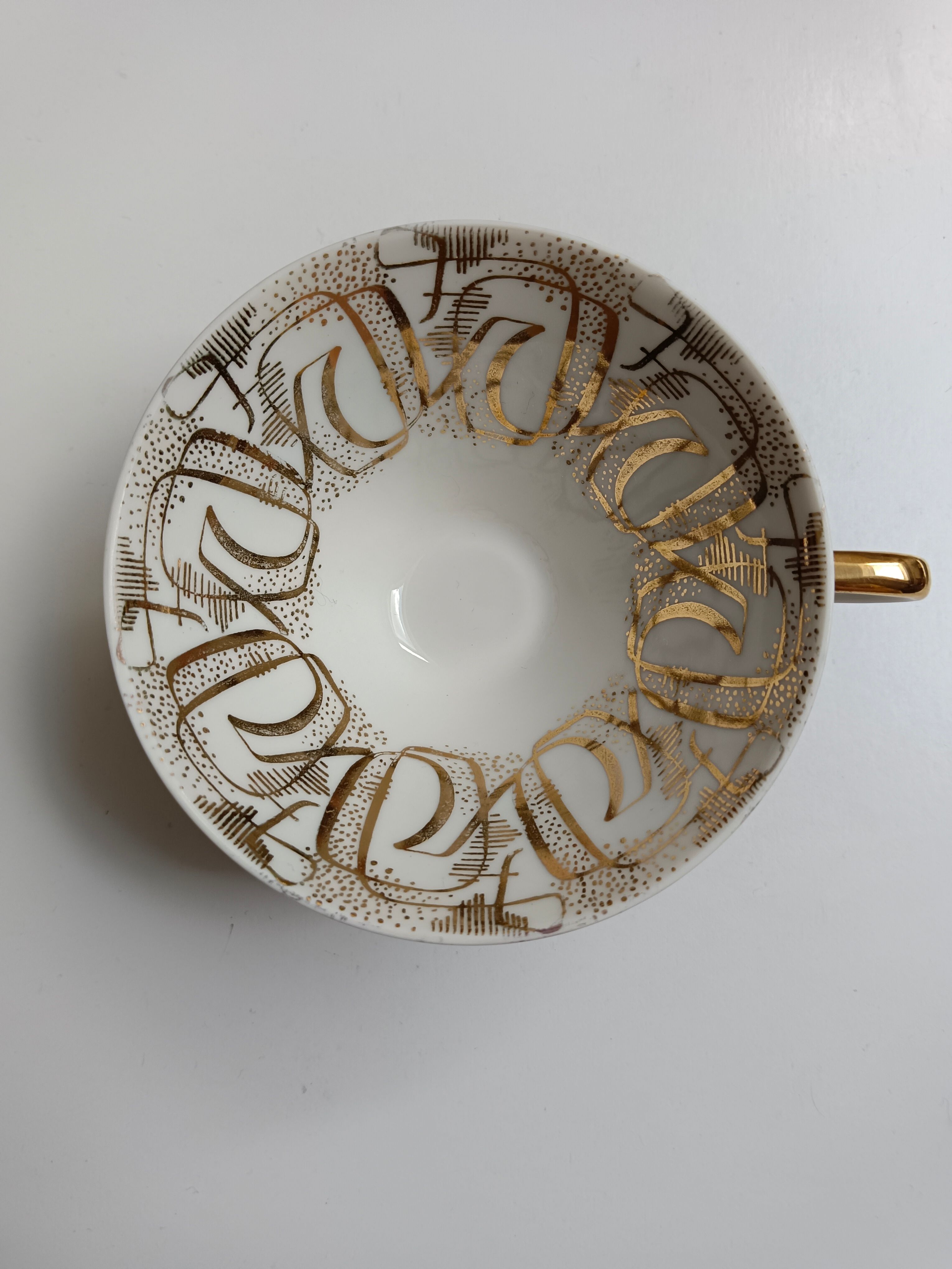 Solitaire tea cup, saucer, and dessert plate in white and gold.