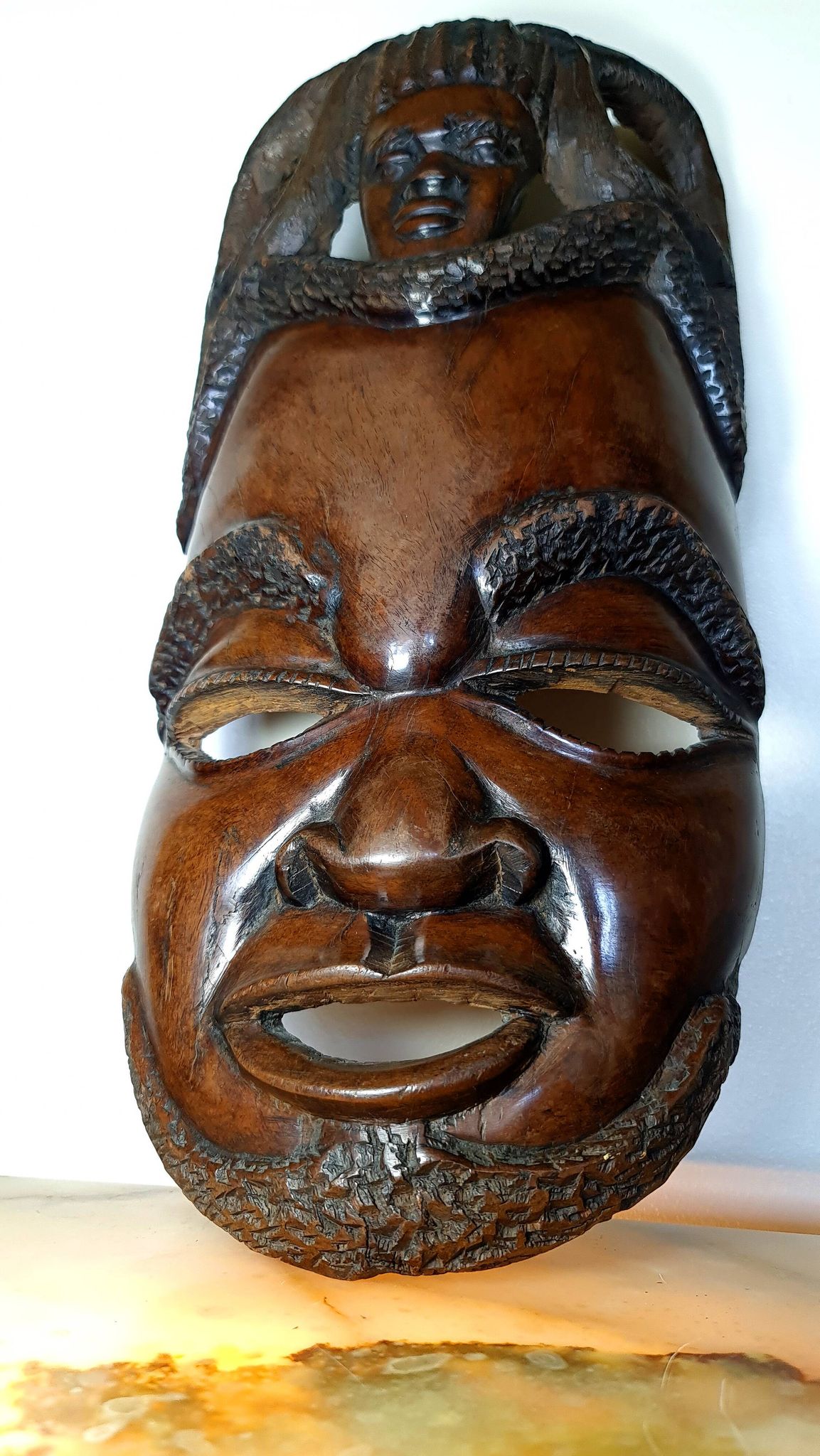 Visage énigmatique d'Afrique sculpté en bois d'ébène