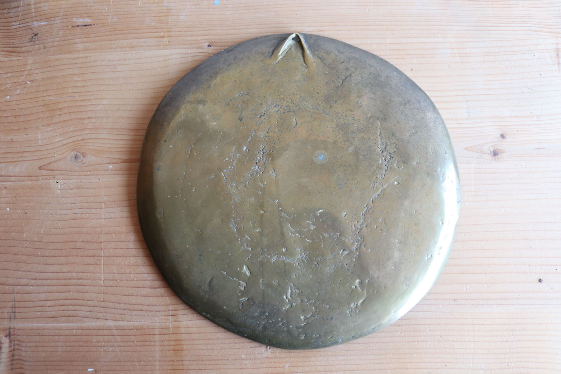 Decorative wall plaque in brass with a floral design.