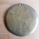 Decorative wall plaque in brass with a floral design.