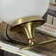 Pair of vintage wall sconces in brass with white glass globe shades.