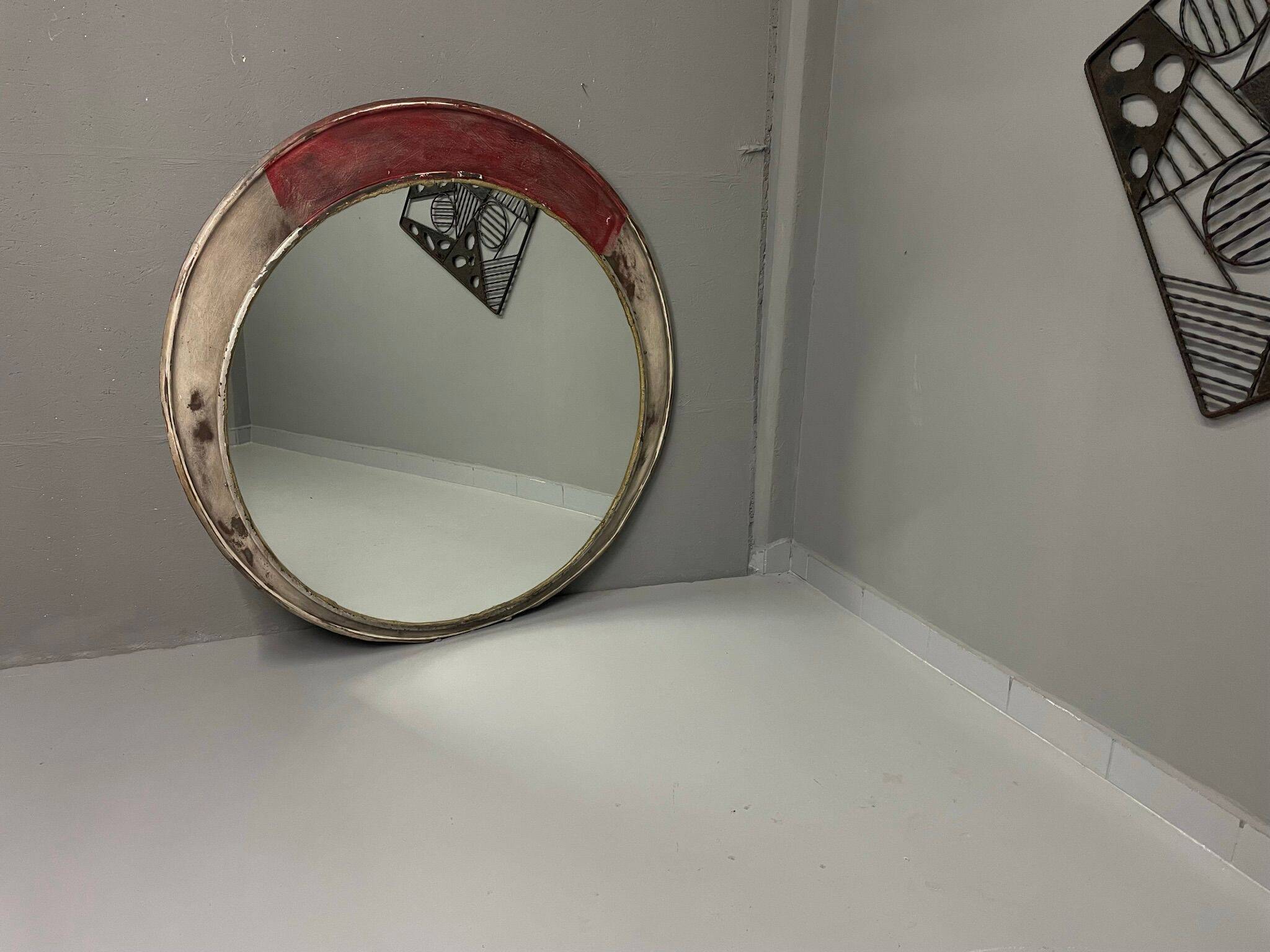 Vintage round mirror with an industrial metal frame in a painted finish.