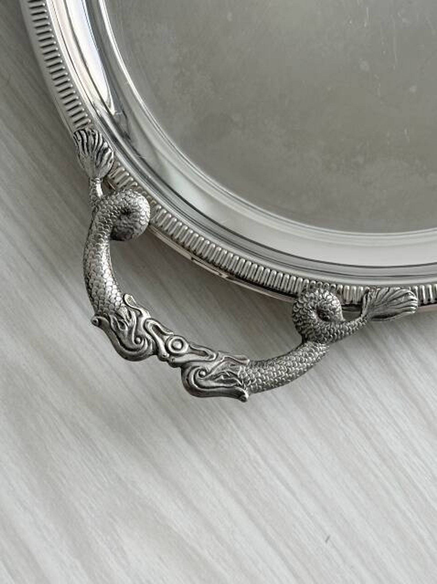 Large stainless steel serving platter with fish-shaped handles.