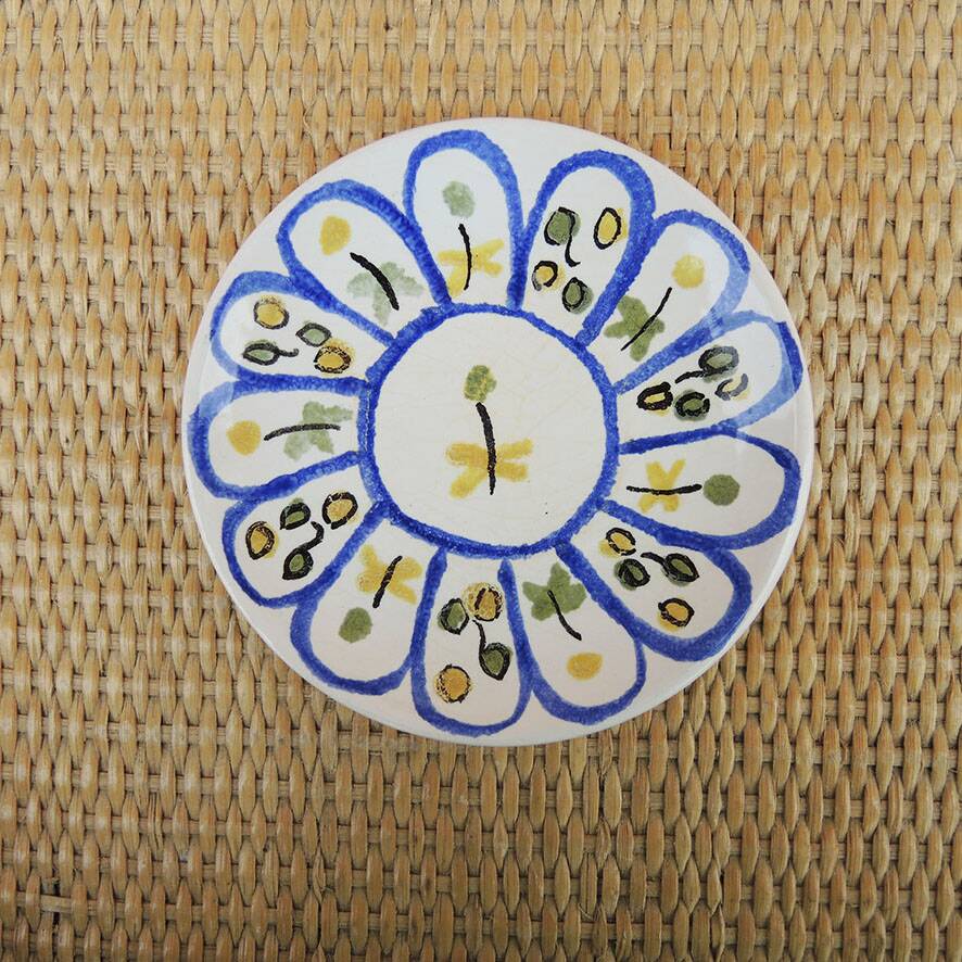 Old ceramic saucer decorated with hand-painted flowers.