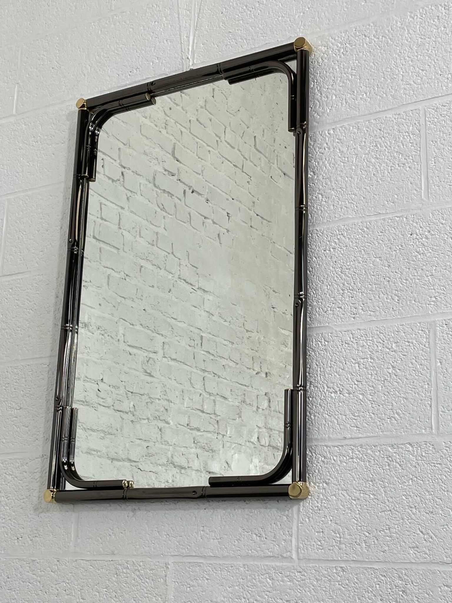 Mirror in black metal and brass with gunmetal finish