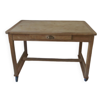 Table de cuisine vintage sur roulettes en bois brut.