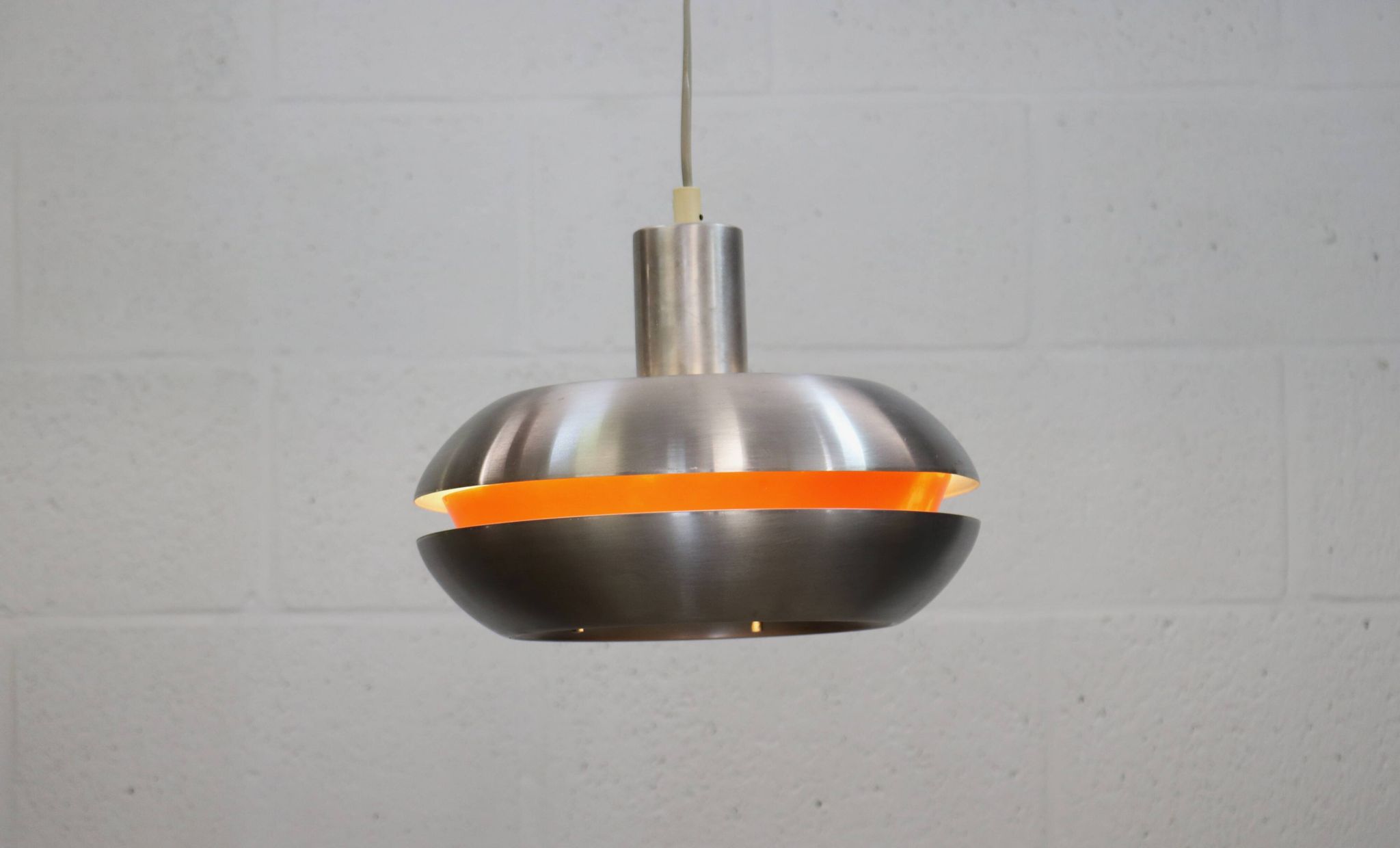 Ancienne lampe de design danois de l'ère spatiale en aluminium avec intérieur orange.