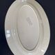 Oval plate Moulin des Loups in blue and red ceramic with a floral design.