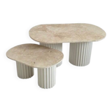 Oval coffee table duo travertine and white fluted wooden legs.