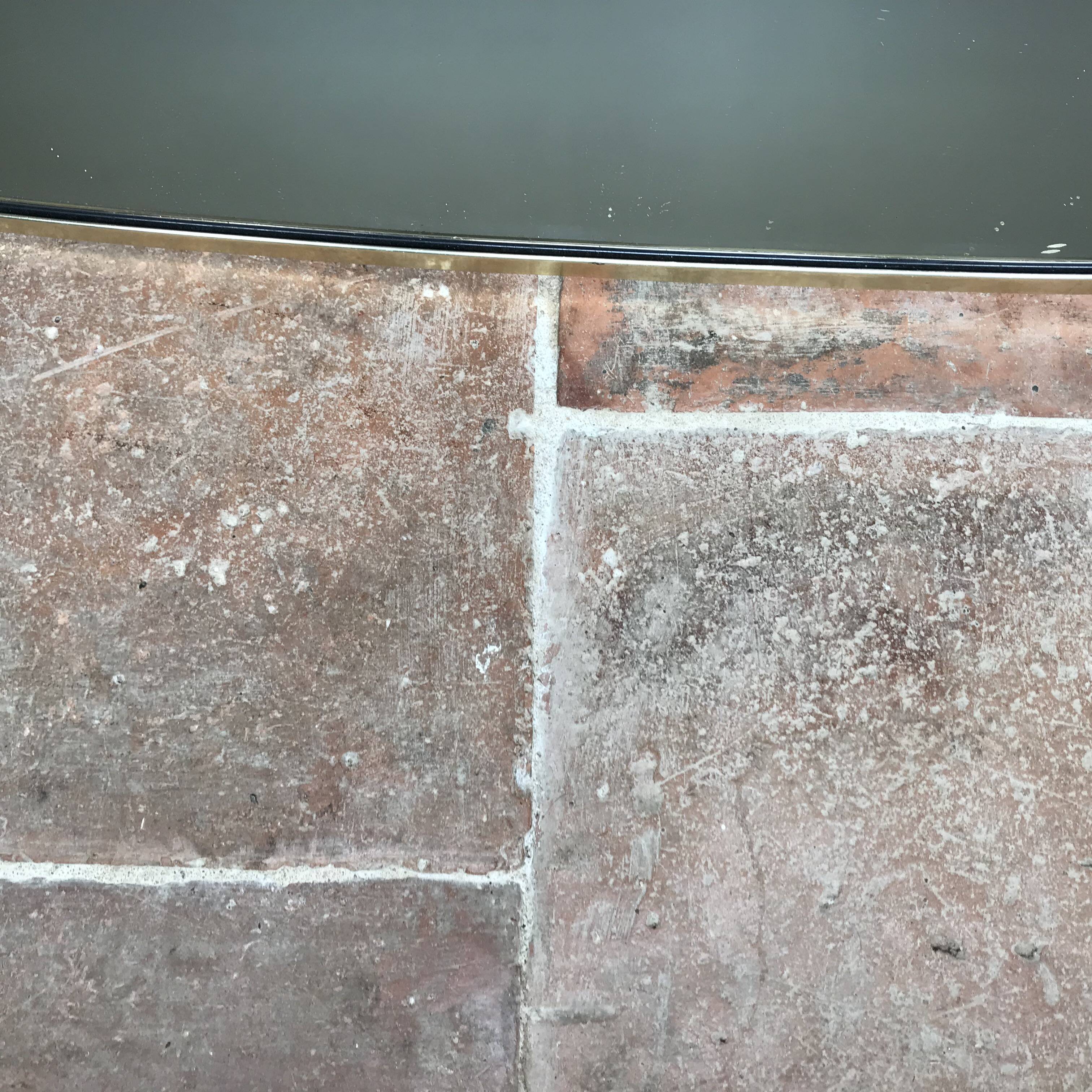 Vintage 1960 free-form mirror known as a retro mirror with a gold and black metal trim.