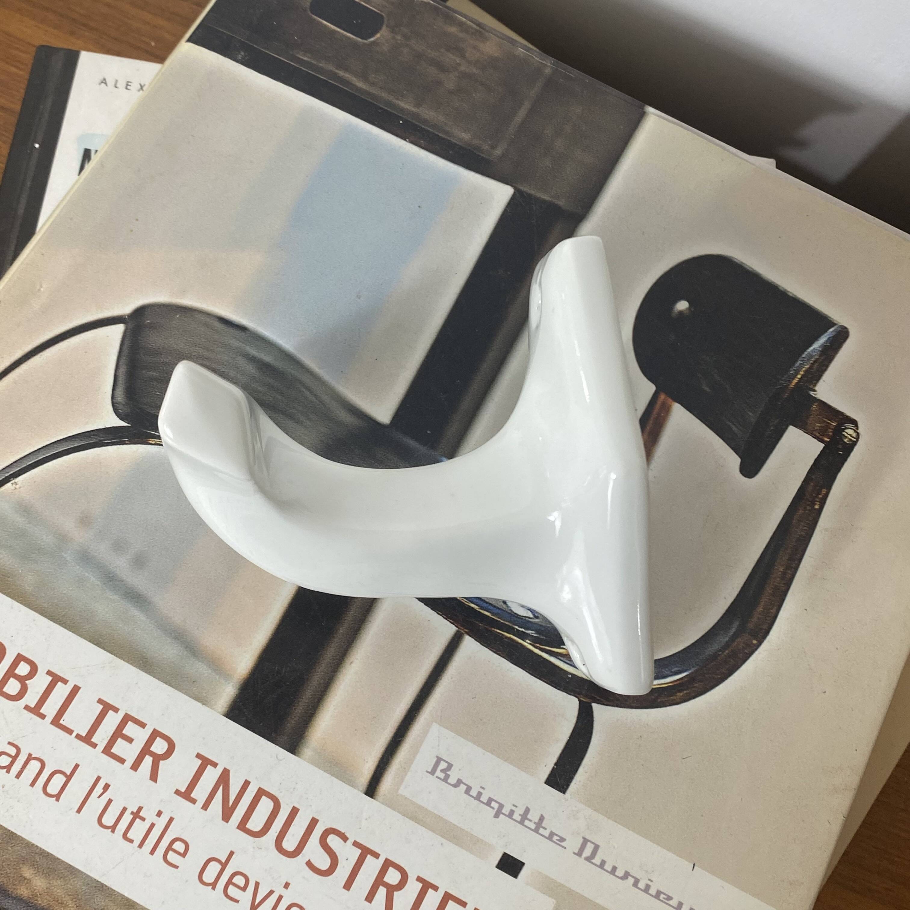 An antique white porcelain coat hook towel holder.