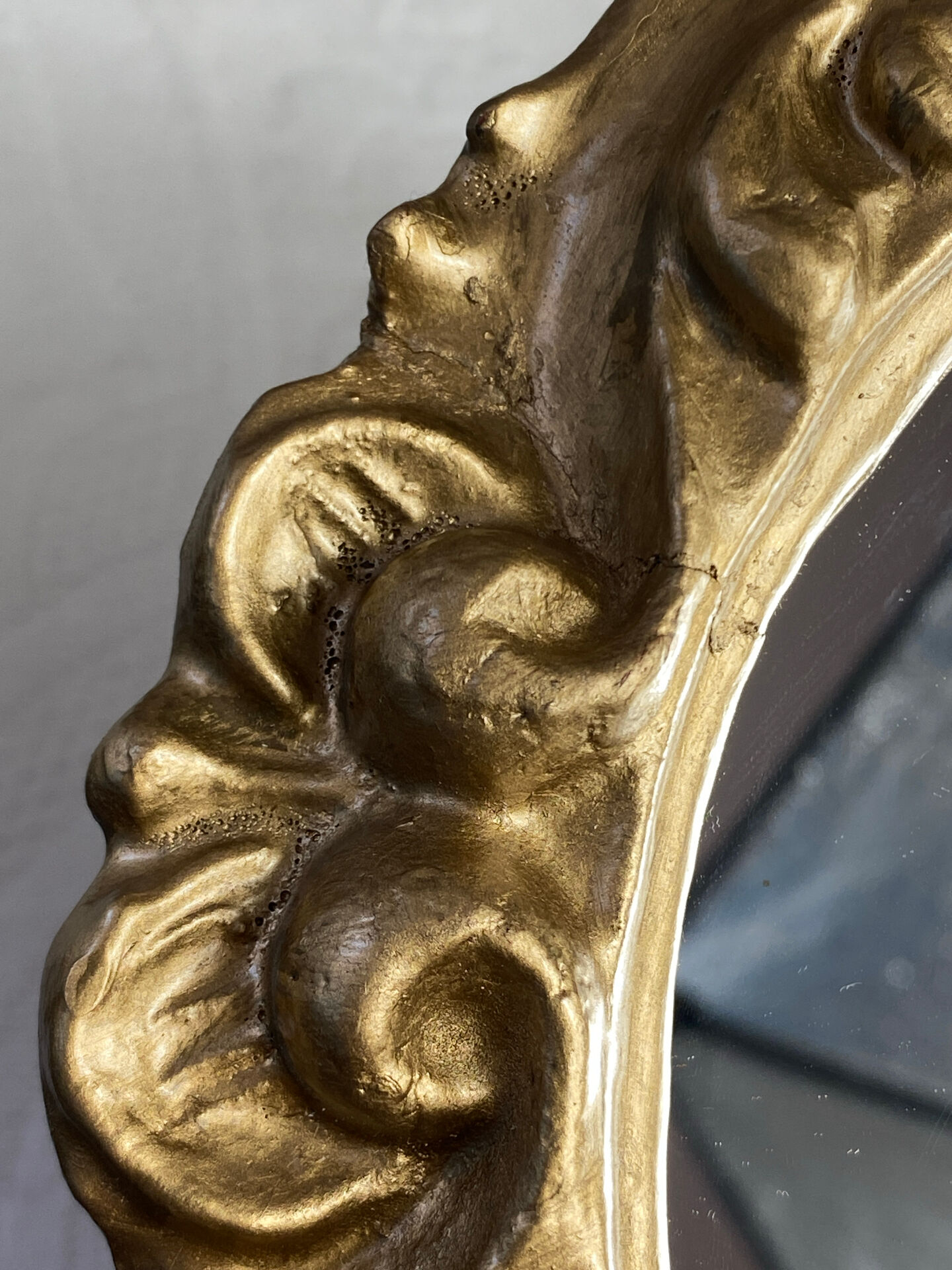 Round wooden mirror in golden colour.