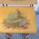 Sets of three nesting tables with painted landscape decorations in poplar.