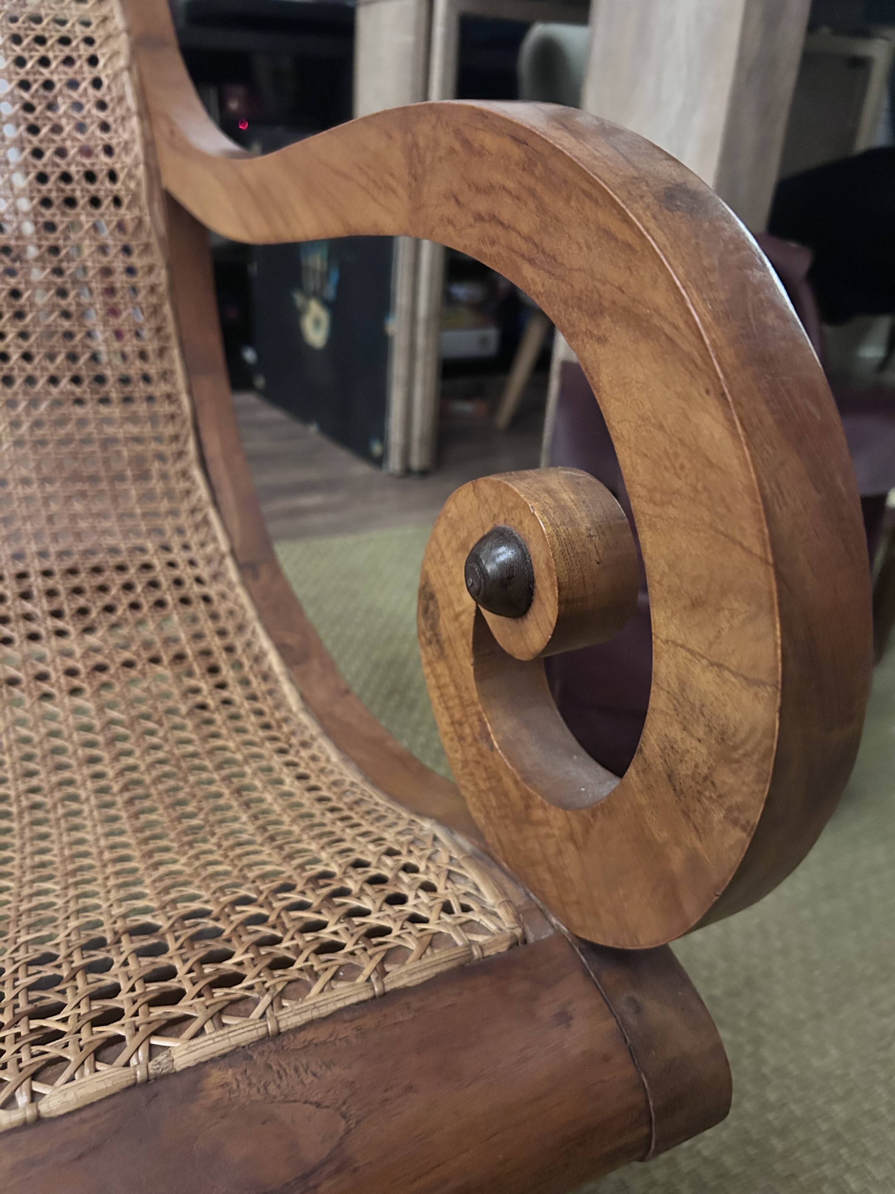 Colonial planter's armchair in solid teak, scroll armrests, caned seat.