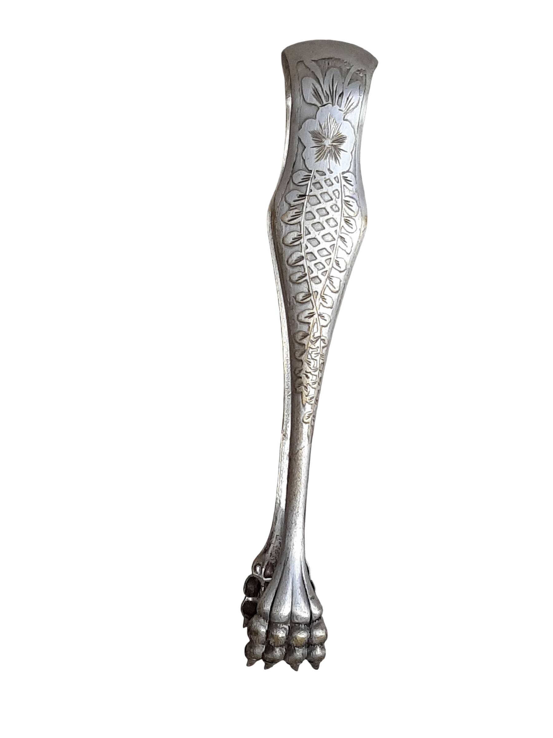 Antique silver-plated sugar tongs with lion's paws.