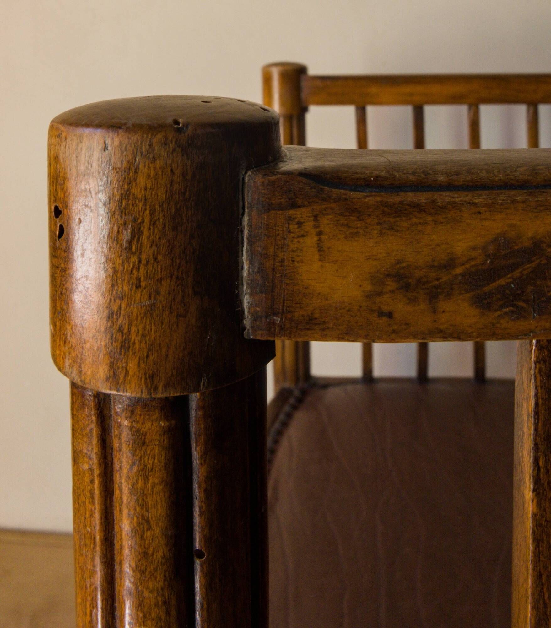 Antique armchair in solid wood and patinated brown leather, early 20th century.