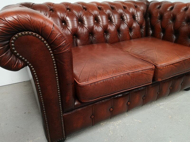 Two-seater brown leather chesterfield sofa