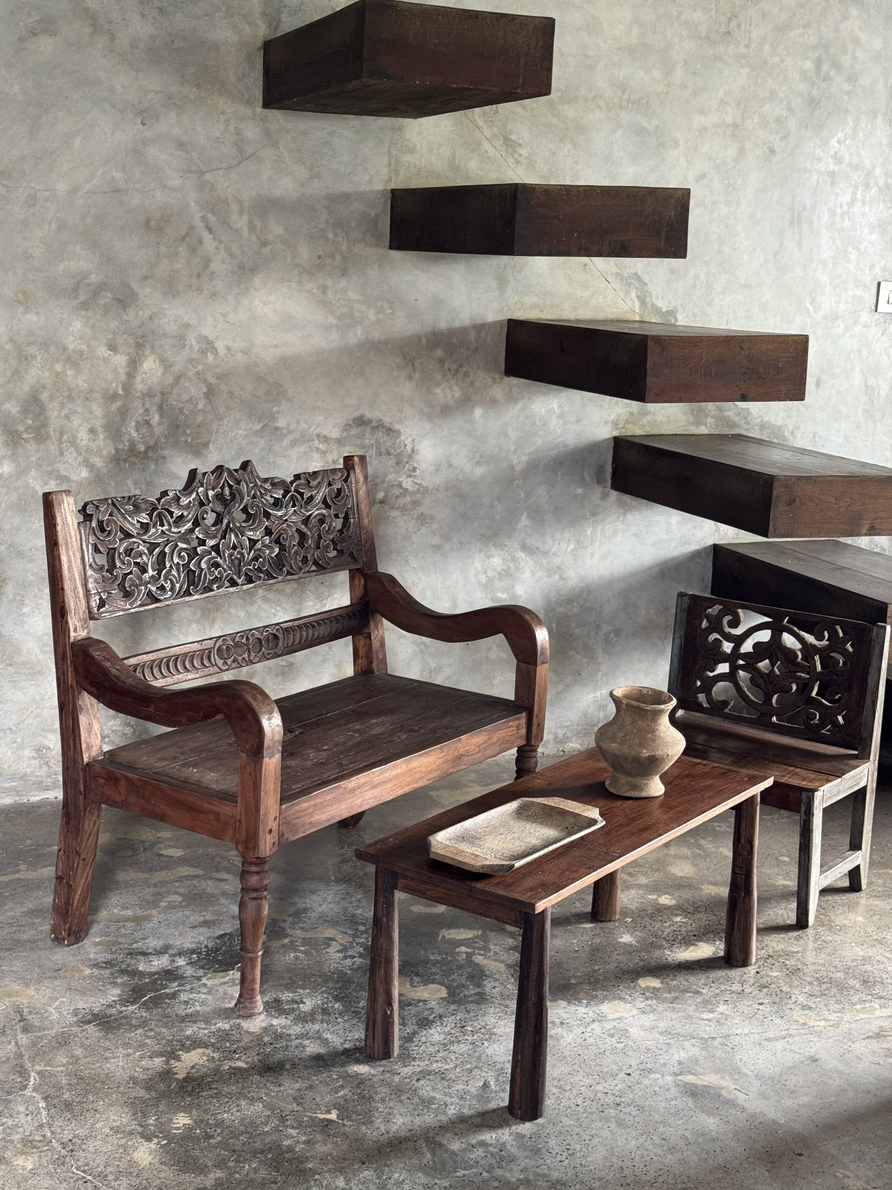 Small antique Indonesian bench in carved teak with plant and floral motifs.