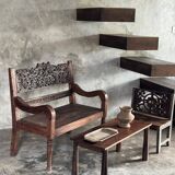 Small antique Indonesian bench in carved teak with plant and floral motifs.