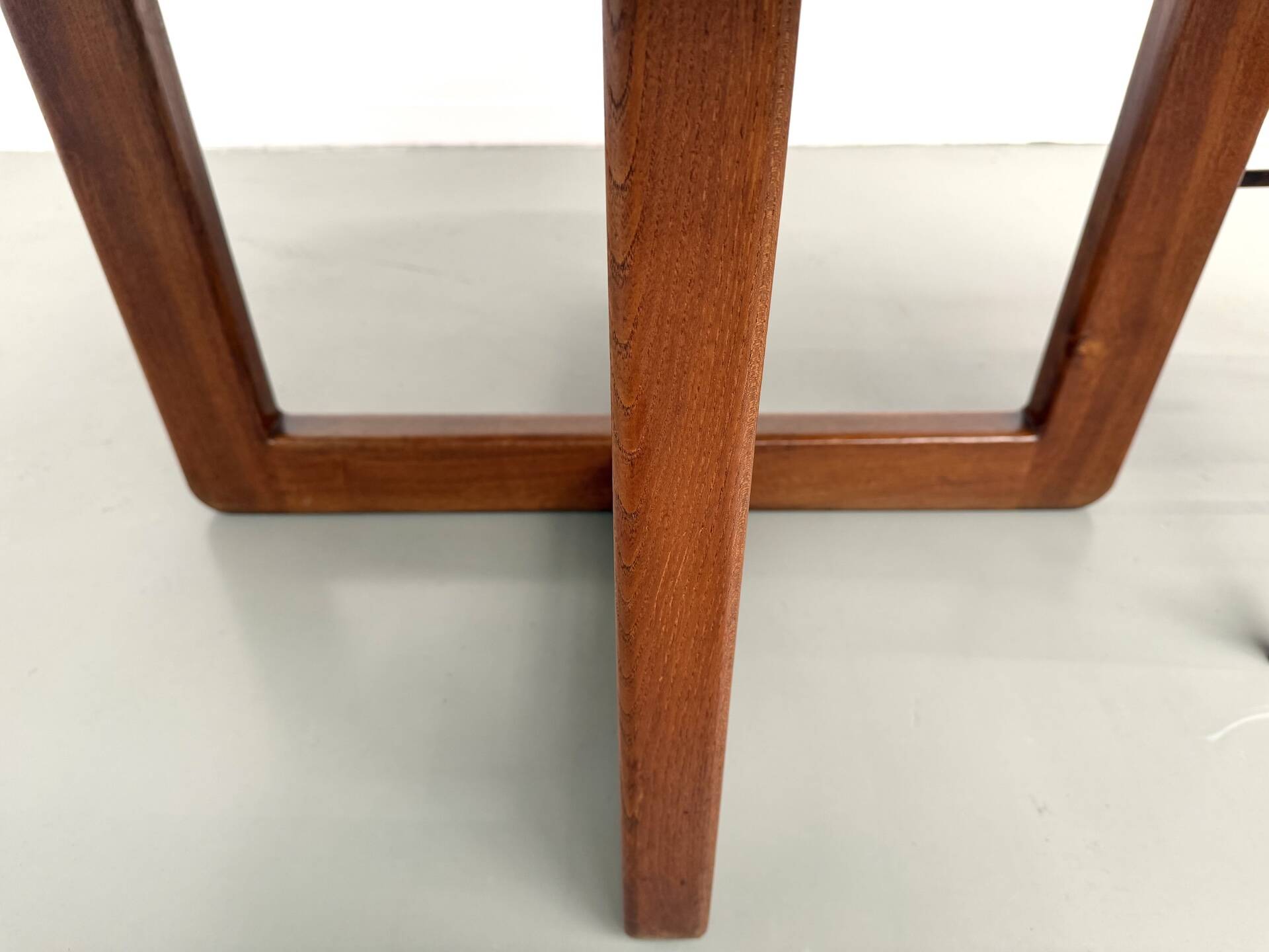 Modernist round table in solid elm, crossed legs.