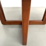 Modernist round table in solid elm, crossed legs.