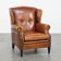 Sheepskin wingback armchair with stitching and black piping