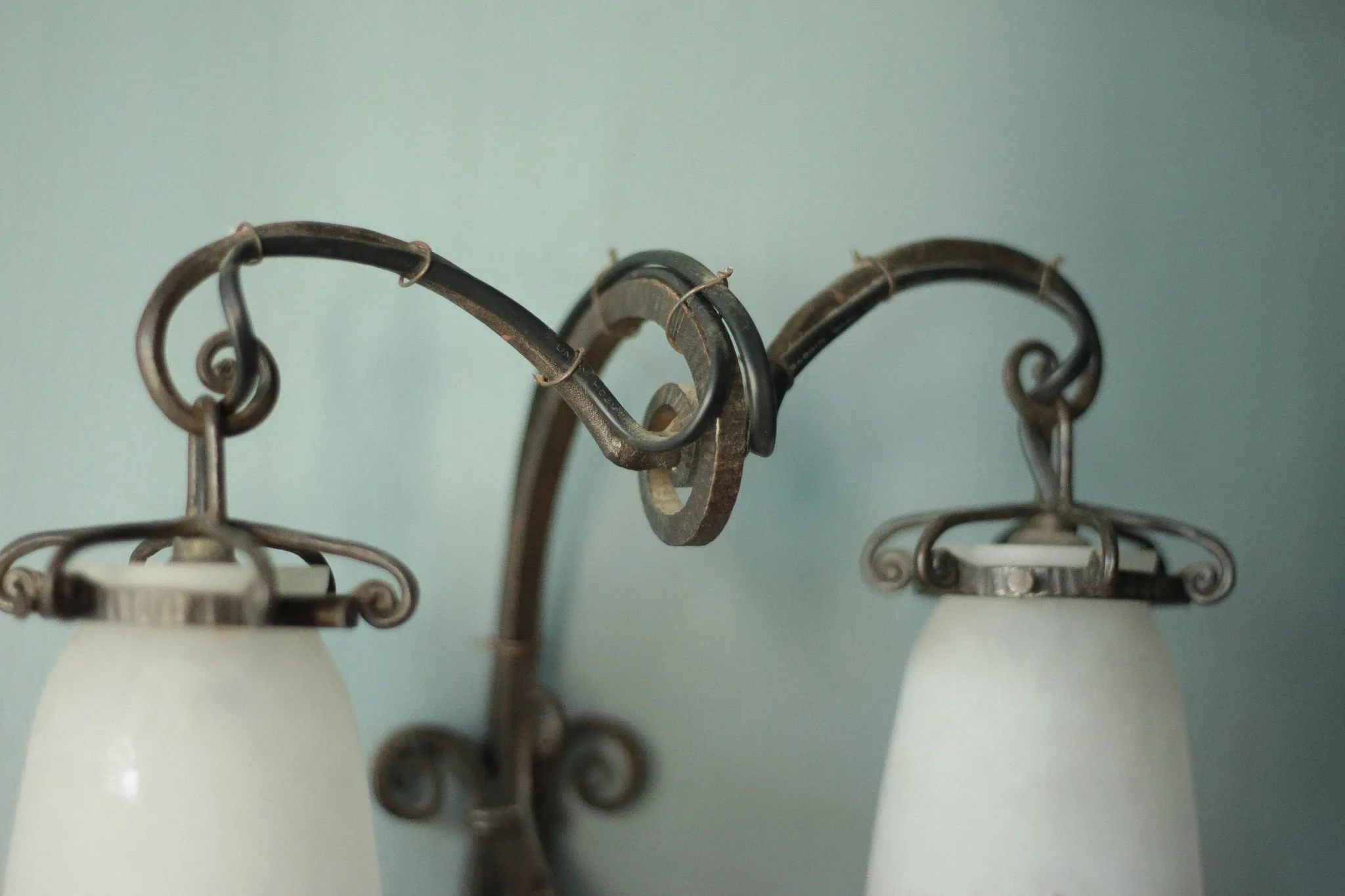 Wall lamp in wrought iron with a pink tulip glass globe by Muller glassworks.