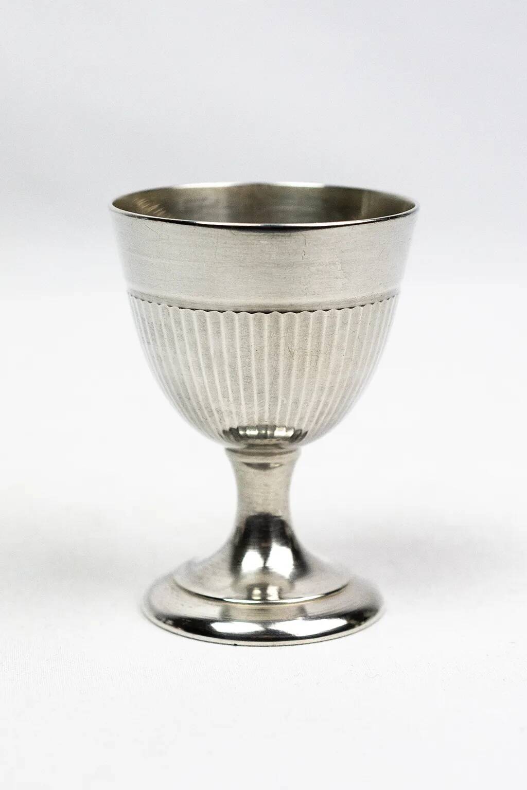 Four silver-plated Christofle egg cups with fluted sides.