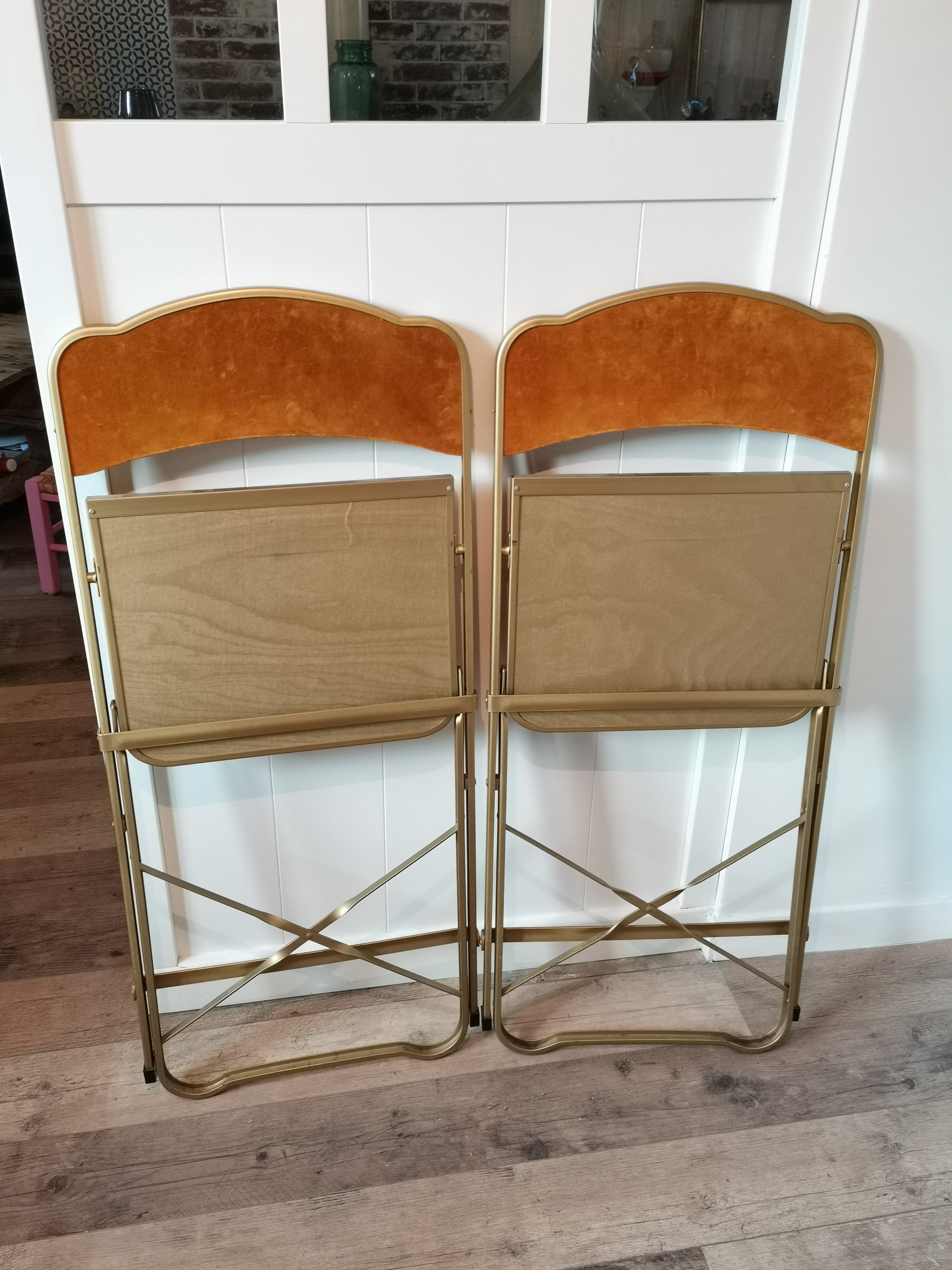 Two gold velvet folding chairs