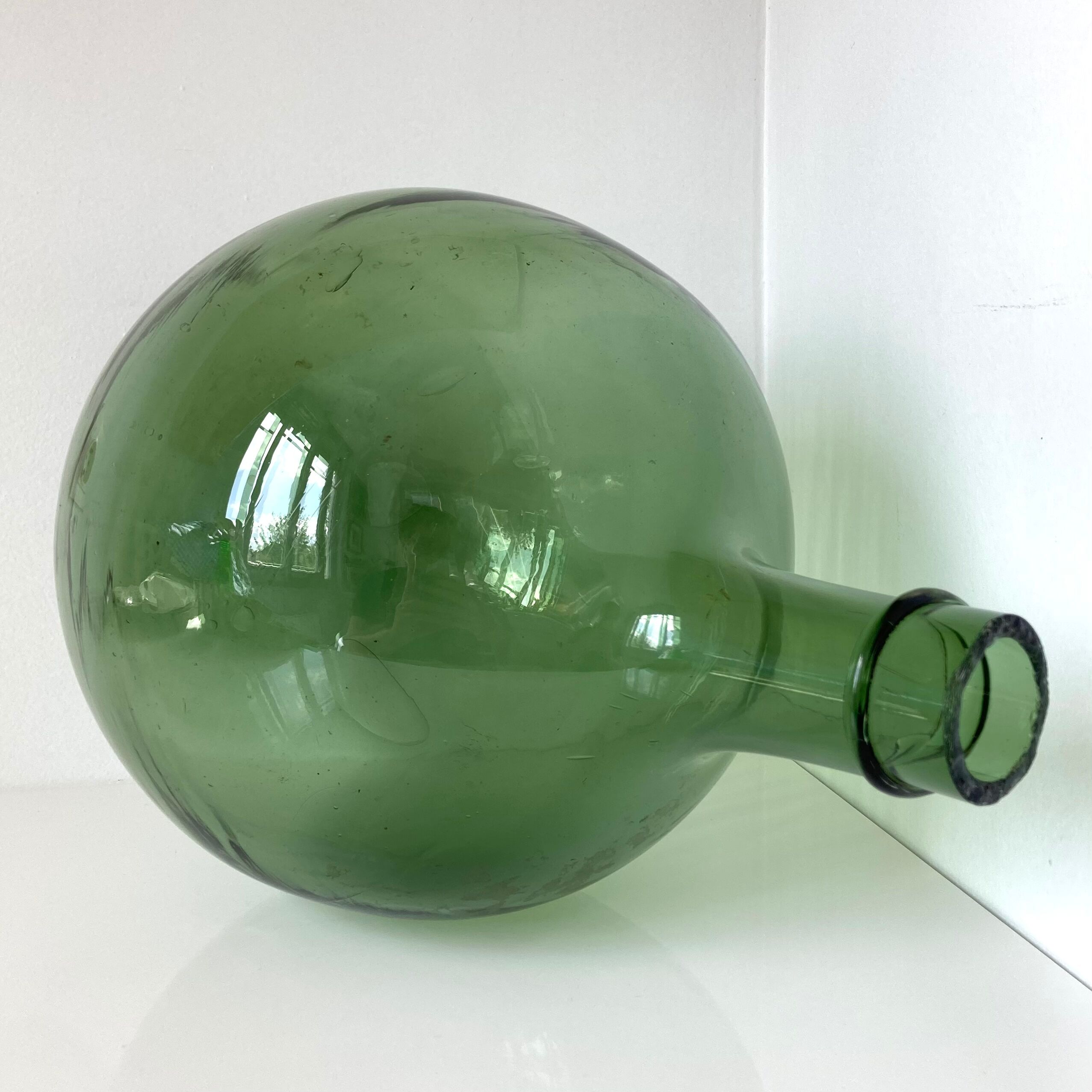 Old demijohn in green glass with ringed neck and hammered opening