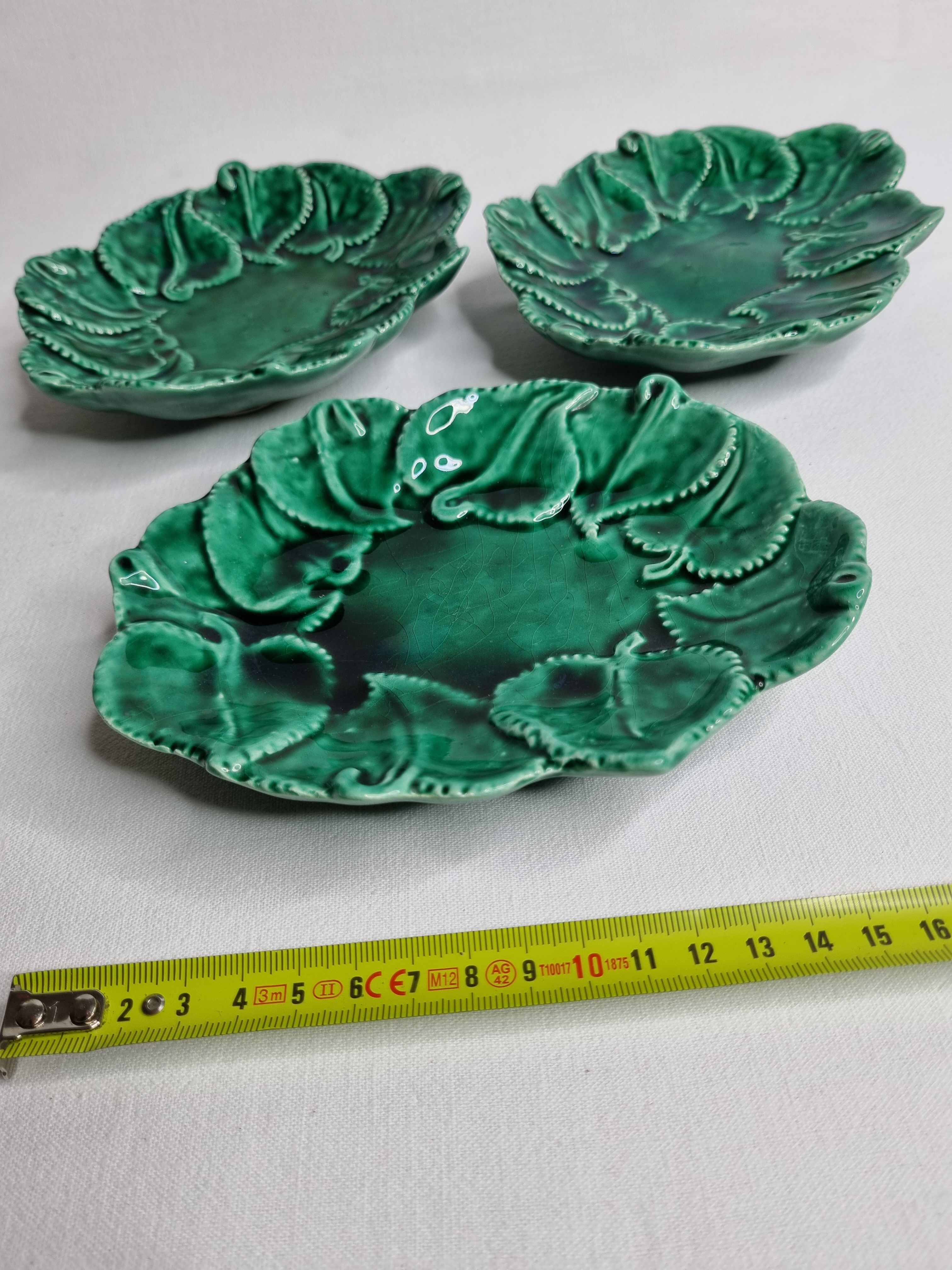 Set of three enamelled, emerald green, leaf-decorated faent cups