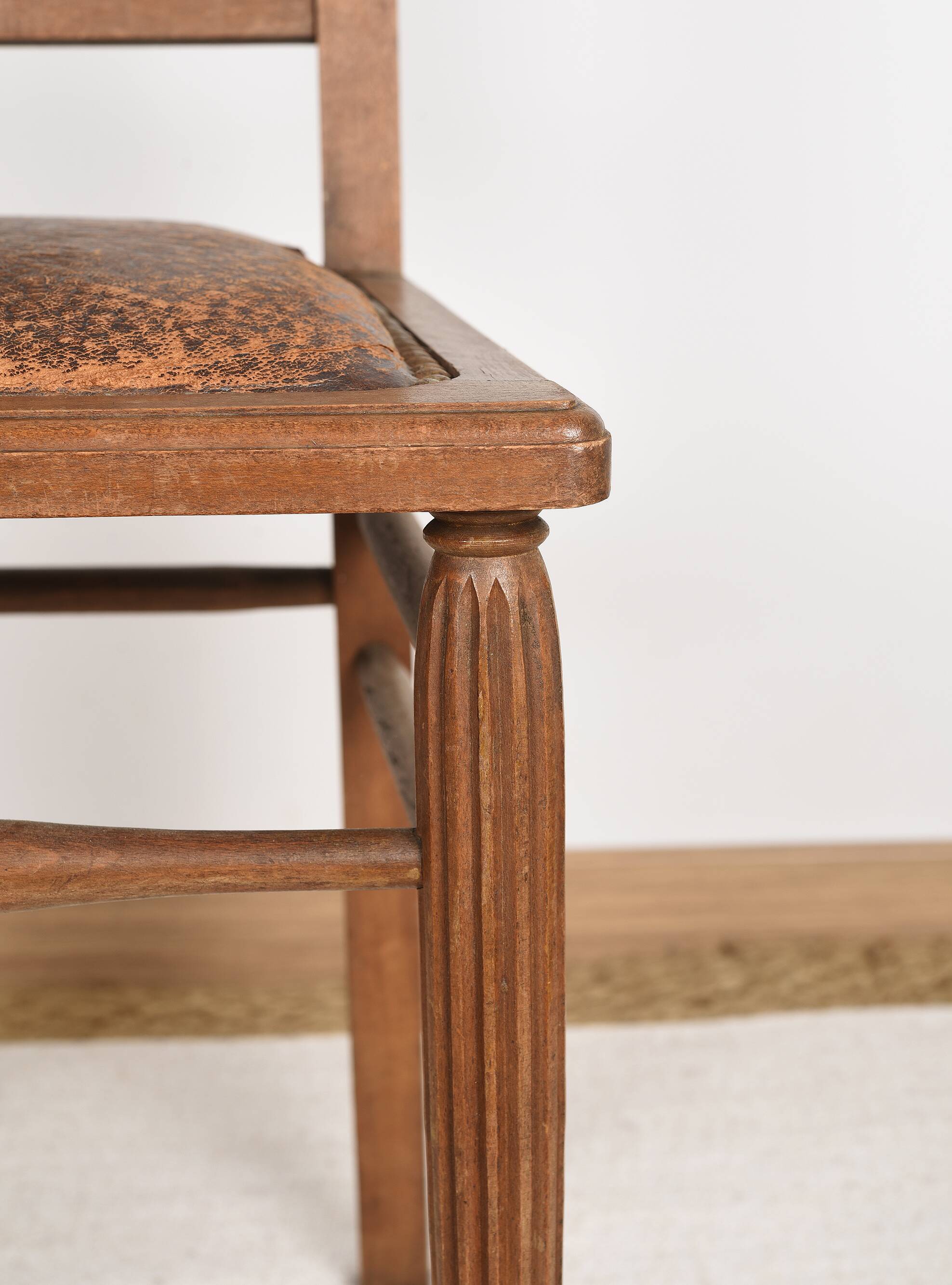 Art Deco style chair in carved wood and leather.