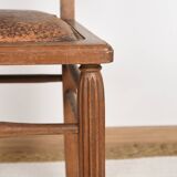 Art Deco style chair in carved wood and leather.