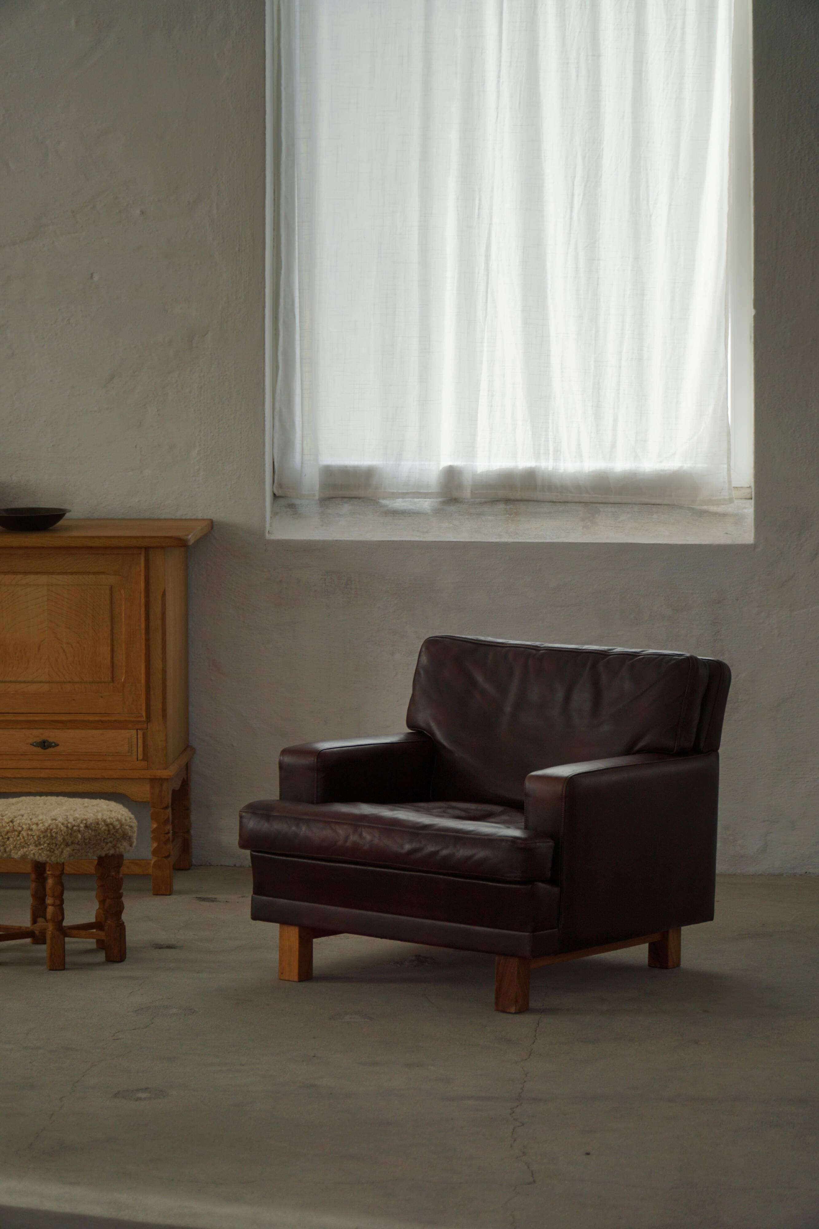 Pair of modern Danish lounge chairs in dark brown leather and rosewood, 1960s.
