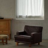 Pair of modern Danish lounge chairs in dark brown leather and rosewood, 1960s.