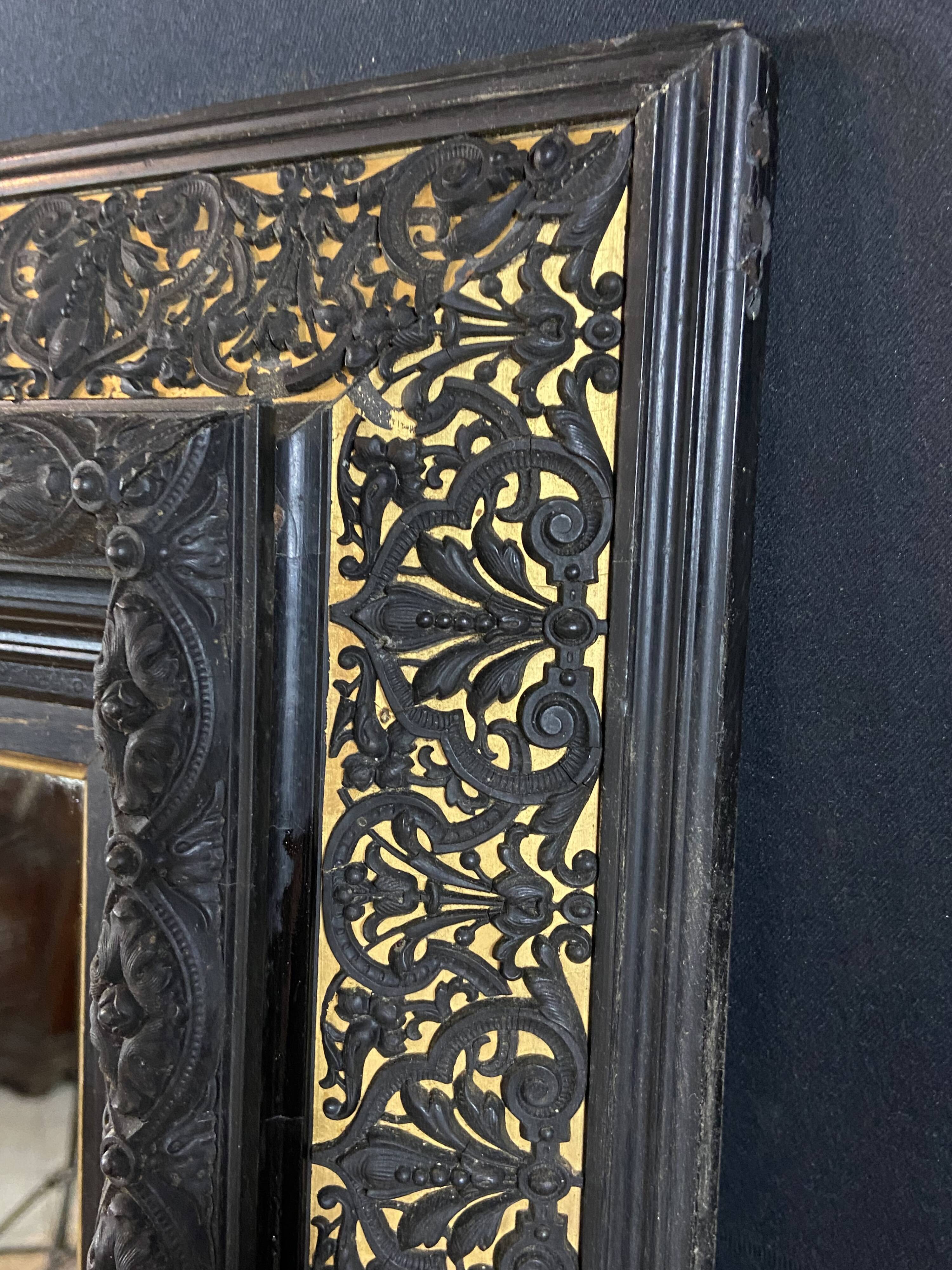 19th-century mirror Napoleon III in blackened wood on a gold background.
