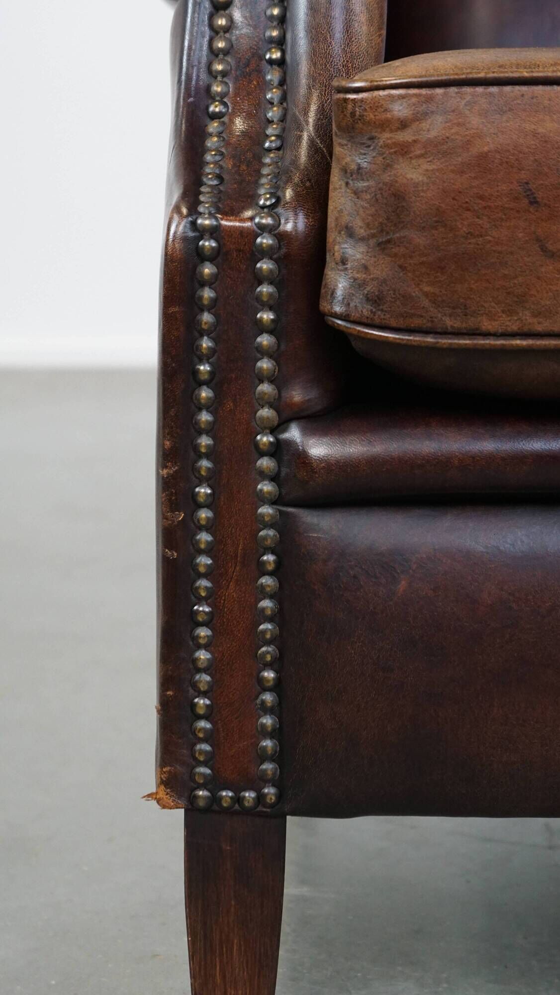 Dark brown sheepskin armchair finished with decorative nails