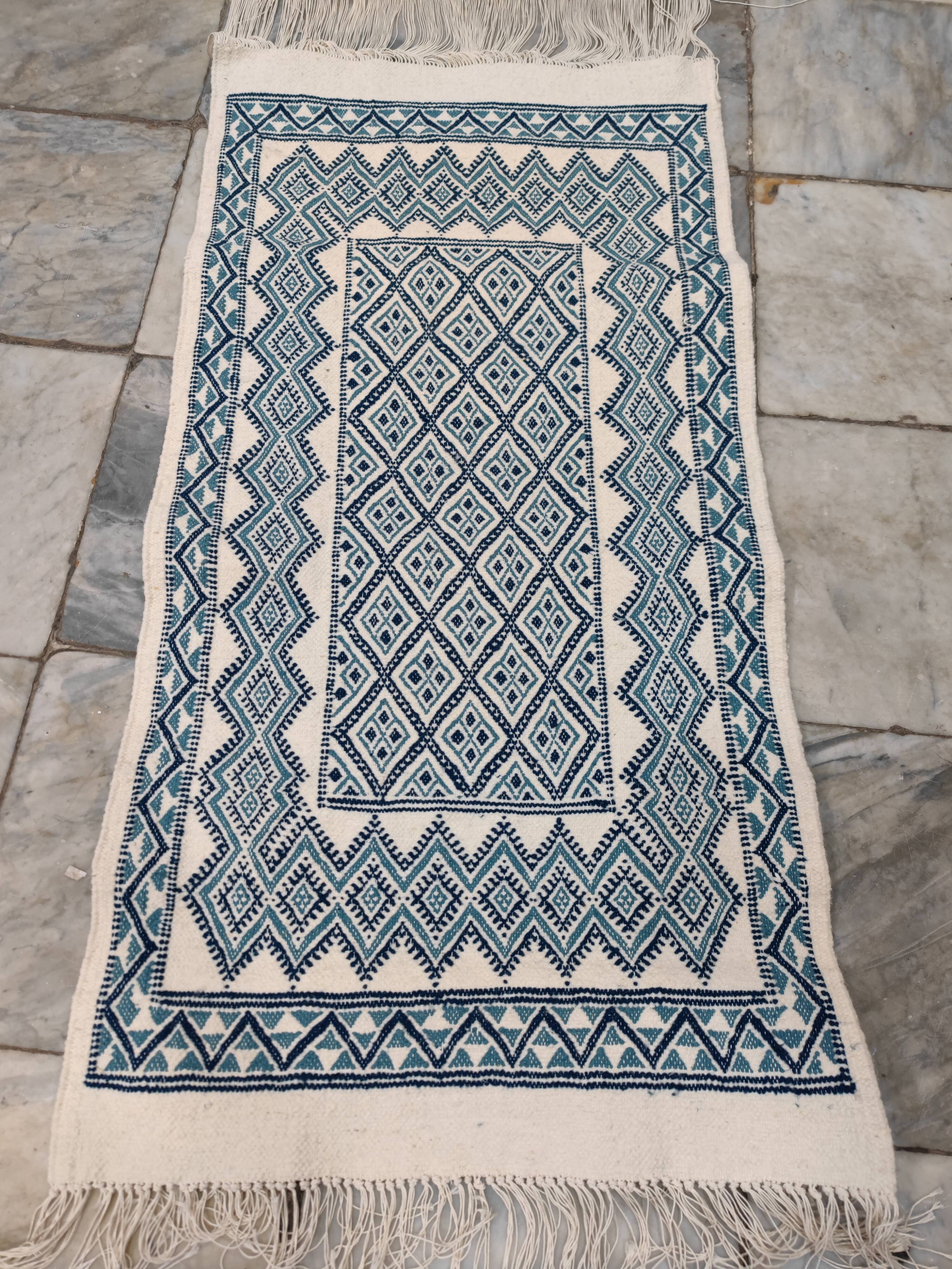 White and blue hand-woven rug in natural wool