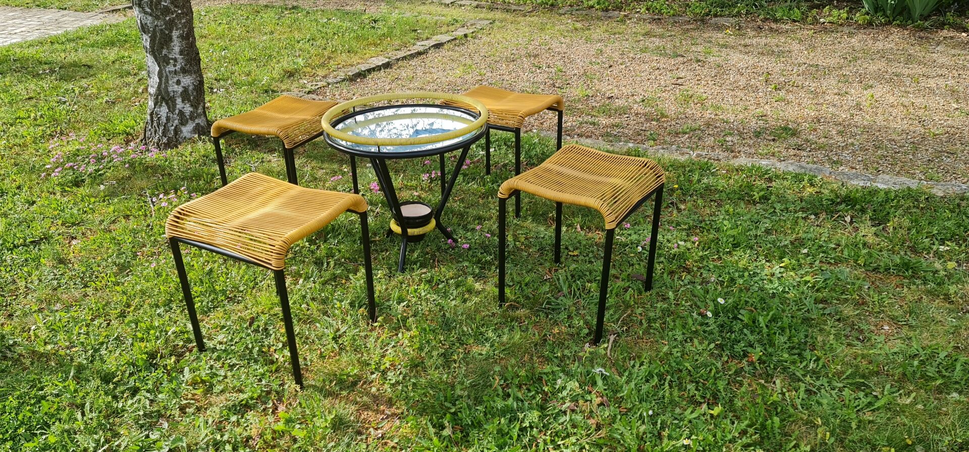 Salon de jardin comprenant table basse ronde en scoubidou et 4 tabourets assortis
