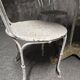 Antique painted wrought iron garden furniture, round table and four chairs.