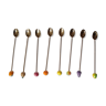 8 golden cocktail spoons with fruit patterns in tip