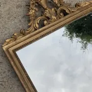 Antique mirror in wood and gilded stucco with a pediment - in the style of the 18th century.
