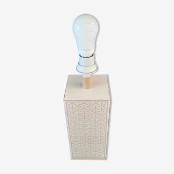 High foot of lace-up desing lamp, off-white background and beige patterns.