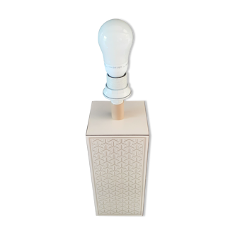High foot of lace-up desing lamp, off-white background and beige patterns.