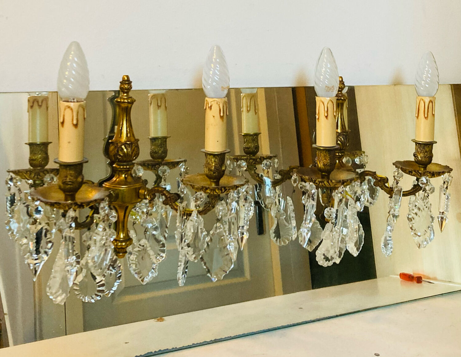 Pair of gilt bronze wall sconces with pendants from the mid-20th century.